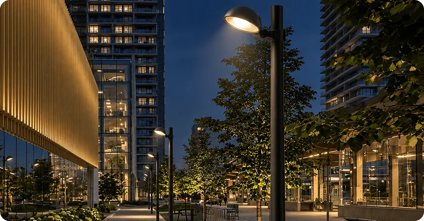 Pole luminaire lighting a courtyard between buildings